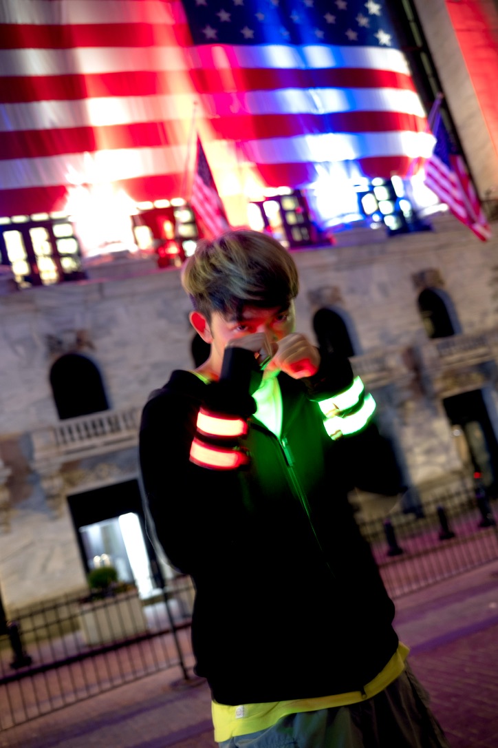 Portrait at night under a lit American flag